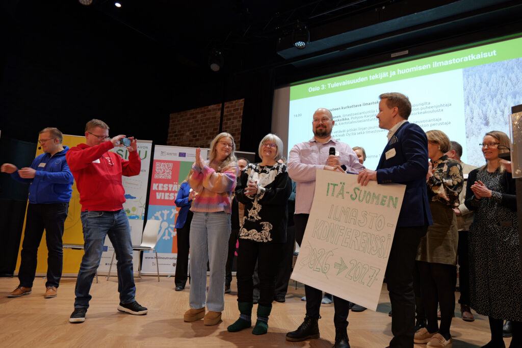 Järjestäjiä rivissä lavalla.