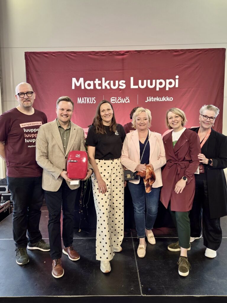 Joukko henkilöitä seisoo rivissä ja katsoo kameraan Luupin avajaisissa.